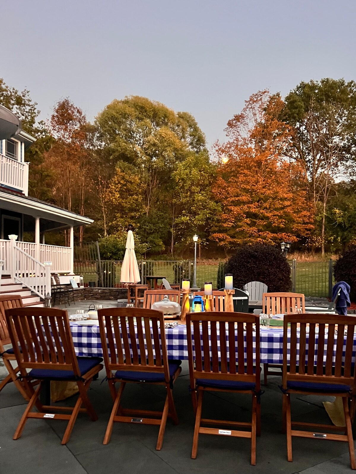 Outdoor dinner event at dusk at Thee Wild Lux — long table, candles, fall foliage